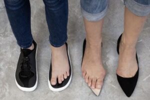 Füße in Barfußschuhen und in High Heels
