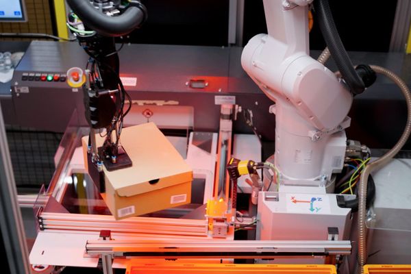 KI-Roboter übernehmen die Handhabung von Schuhkartons.