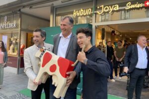 Eine Kuh als Gastgeschenk für den Münchner Flagstore: Diskuswurf-Legende Lars Riedel zwischen Claudio Minder und Karl Müller.