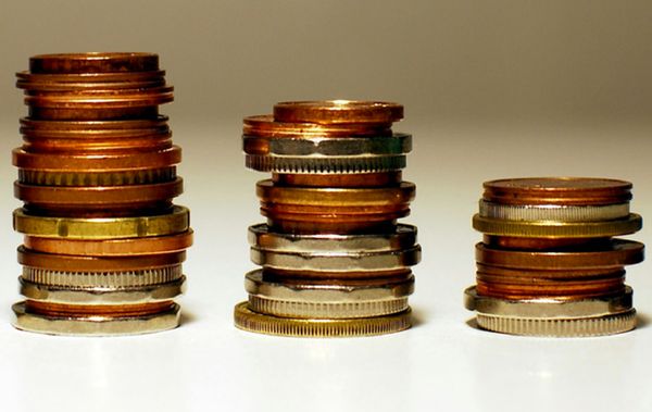 Gestapelte Münzen in unterschiedlichen Höhen symbolisieren finanzielle Schwankungen und wirtschaftliche Trends.