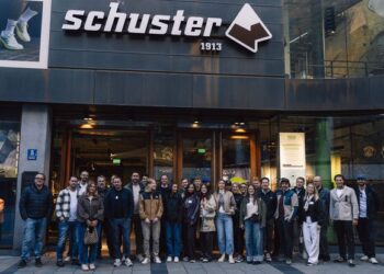 Gruppe junger Unternehmer steht vor einem Schuster-Geschäft in München während eines ANWR-Treffens