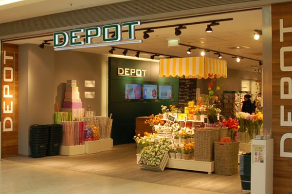 Depot-Filiale mit Schaufenster, Verkaufstheke und Produktdisplays in einem Einkaufszentrum.