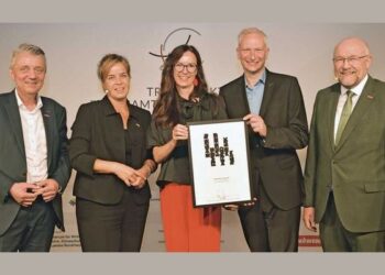Fünf Personen in Business-Kleidung halten ein Zertifikat und eine Urkunde in die Kamera, anlässlich einer Preisverleihung für Ehrenamt.