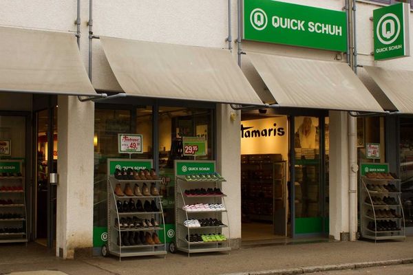 Geschlossene Quick Schuh Filiale mit grüner Fassade und Schaufenstern an einer Straße in Esslingen