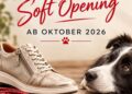 Beiger Sneaker mit Schnürsenkeln neben Porträt eines schwarz-weißen Hundes, Schriftzug "Soft Opening AB Oktober 2026
