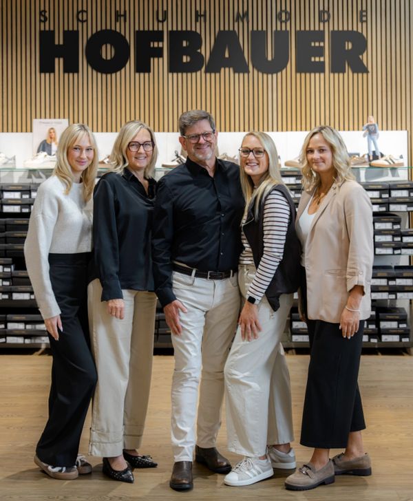 Fünf Personen stehen in einer Hofbauer-Filiale und posieren für ein Gruppenfoto.